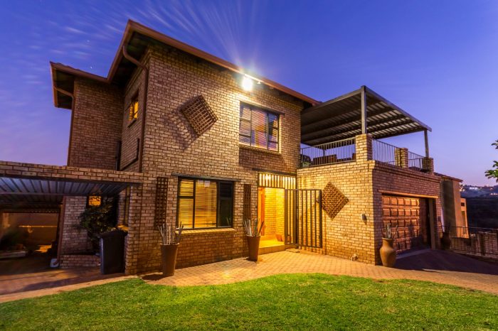 Property photography — double-storey face-brick home photographed at dusk